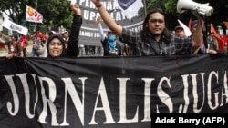 Wartawan nasional mengangkat tangan saat mereka berbaris bersama dengan buruh Indonesia selama rapat umum untuk memperingati May Day di Jakarta, 1 Mei 2007. (Foto: AFP)
