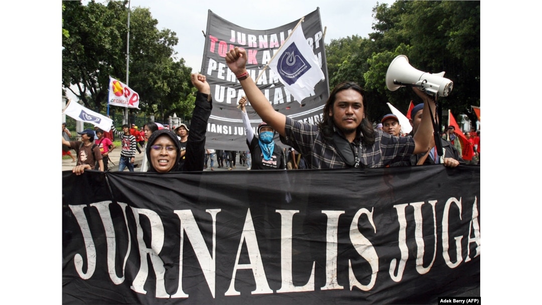 Wartawan nasional mengangkat tangan saat mereka berbaris bersama dengan buruh saat memperingati May Day di Jakarta, 1 Mei 2007. (Foto: AFP)