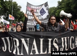 Wartawan nasional mengangkat tangan saat mereka berbaris bersama dengan buruh saat memperingati May Day di Jakarta, 1 Mei 2007. (Foto: AFP)
