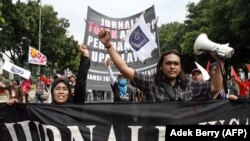 Wartawan mengangkat tangan saat mereka berbaris bersama dengan buruh Indonesia dalam pawai memperingati hari Buruh di Jakarta, 1 Mei 2007. (Foto: AFP)