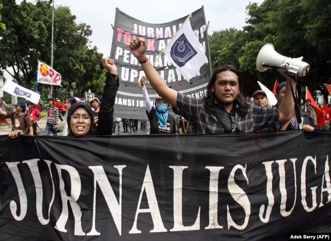 Wartawan nasional mengangkat tangan saat mereka berbaris bersama dengan buruh saat memperingati May Day di Jakarta, 1 Mei 2007. (Foto: AFP)
