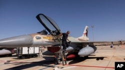 FILE - An Israeli technician checks an air force fighter jet during the bi-annual multi-national aerial exercise known as the Blue Flag, at Ovda airbase near Eilat, southern Israel, Oct. 24, 2021.