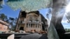 A residential building is seen through a windshield of a destroyed car in the town of Irpin, northwest of Kyiv, Ukraine, June 3, 2022, the 100th day of the Russian invasion of the country.