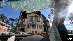 A residential building is seen through a windshield of a destroyed car in the town of Irpin, northwest of Kyiv, Ukraine, June 3, 2022, the 100th day of the Russian invasion of the country.