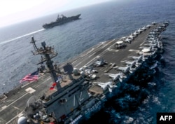 This handout picture released by the US Navy on May 17, 2019 shows the Nimitz-class aircraft carrier USS Abraham Lincoln (CVN 72) and the Wasp-class Amphibious Assault Ship USS Kearsarge (LHD 3)
