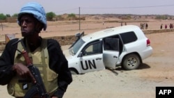 FILE- In this file photo taken on July 16, 2016 shows a soldier of the United Nations mission to Mali MINUSMA standing guard near a UN vehicle after it drove over an explosive device near Kidal, northern Mali.