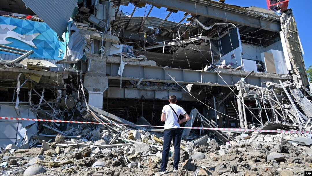 Čovek gleda zgradu supermarketa delimično razorenu raketom, na obodu Kijeva, 8. juna 2022. (Foto: AFP/Sergey Bobok)