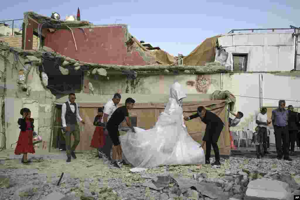 Palestinian bride Rabiha al-Rajby and groom Mohyeldin Nasrallah start their wedding ceremony from the ruins of al-Rajby's home in east Jerusalem neighborhood of Silwan, June 11, 2022.