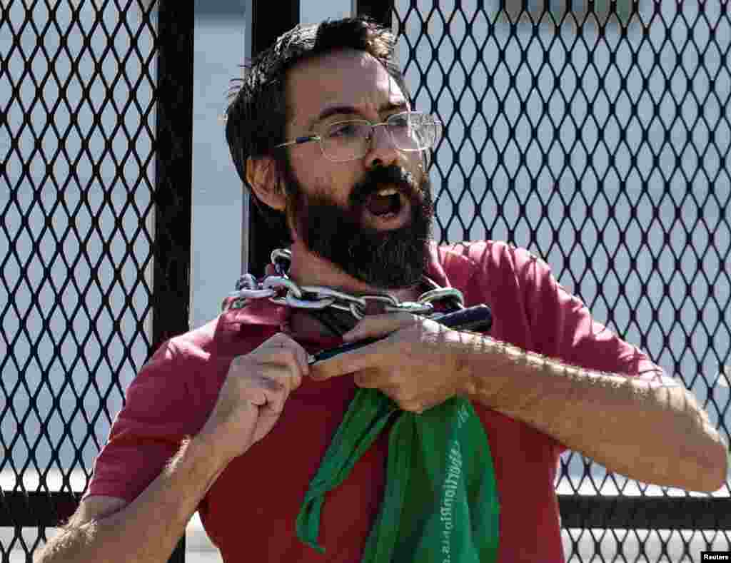 An abortion rights activist chains himself to security fencing while protesting outside the U.S. Supreme Court in Washington.