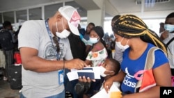 Etienne Ilienses revisa los documentos de su familia para un vuelo a Chile, en el Aeropuerto Internacional Toussaint Louverture, en Puerto Príncipe, Haití, el domingo 30 de enero de 2022. “Para llegar a Estados Unidos, me enfrenté al infierno”, dijo. Aún así, no descartó volver a hacerlo “porque Haití no ofrece nada a sus niños. Nos vemos obligados a sufrir humillaciones, afrentas en todas partes". (Foto AP/Odelyn Joseph)