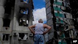 A man stands looking at a building destroyed during attacks, in Borodyanka, on the outskirts of Kyiv, Ukraine, June 4, 2022.