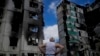 Čocek gleda u stambenu zgradu unišentu u ruskom bombarovanju, u Borodjanki, nedaleko od Kijeva, 4. juna 2022.
