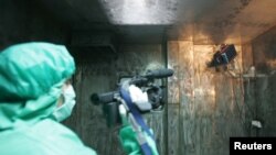 A technician from Iran's Atomic Energy Organisation films a surveillance camera installed by the International Atomic Energy Organisation in the Uranium Conversion Facility in Isfahan, south of Tehran, Aug. 8, 2005.