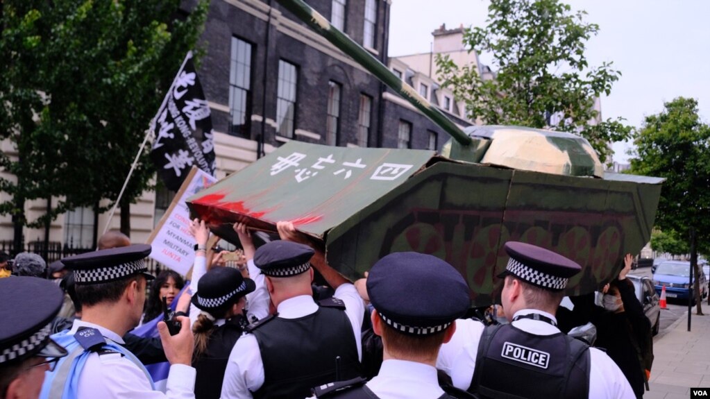 2022年6月4日，伦敦警察在中国驻英国大使馆外阻止示威者抬着的纸扎坦克走近大使馆范围。 （美国之音郑乐捷）(photo:VOA)