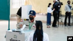A police officer drops his ballot at a polling station in Takhmua in Kandal province, southeast of Phnom Penh, Cambodia, June 5, 2022. 