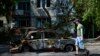 A man carries water in front of an apartment building damaged in an overnight missile strike, in Sloviansk, Ukraine, May 31, 2022.