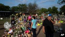 Rene Lucero y su esposa Alva visitan un sitio de homenaje tras el tiroteo en la Escuela Primaria Robb en Uvalde, Texas, el 31 de mayo de 2022. 