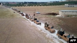 This aerial view shows Turkey-backed Syrian fighters as they arrive to take part in a military exercise in the countryside of the northern city of Manbij, June 2, 2022. 