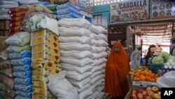 A woman walks past sacks of wheat flour piled high in the Hamar-Weyne market in the capital Mogadishu, Somalia, May 26, 2022. 