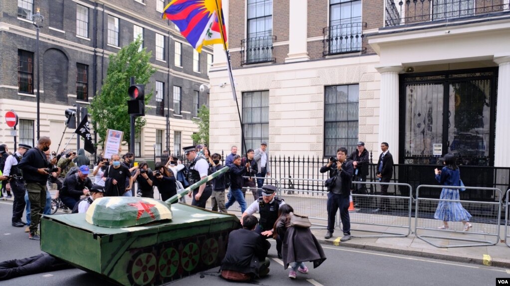 示威者把纸扎坦克摆在中国驻英大使馆外，并且把纸扎坦克的炮口指向大使馆。 （美国之音郑乐捷）