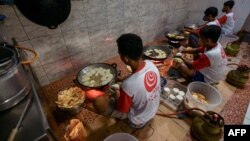 Employees fry sliced tempe, a traditional Indonesian food made from fermented soybeans, at a home industry that produces chips in Jakarta May 18, 2022