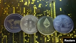 ARCHIVO - Representaciones de las monedas virtuales Ripple, Bitcoin, Ethereum y Litecoin se ven en una placa base de PC en esta imagen ilustrativa. 