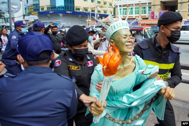 FILE - Cambodian-U.S. human rights advocate Theary Seng, dressed as Lady Liberty, is arrested by police after being found guilty of treason in her trial in front of the Phnom Penh municipal court, June 14, 2022.