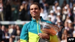 Spain's Rafael Nadal poses with The Musketeers' Cup as he celebrates after victory over Norway's Casper Ruud during their men's singles final match on day fifteen of the Roland-Garros Open, June 5, 2022.