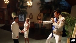 Brian Mills, right, as Elvis marries Richard Johnson and Cheryl Bell of Peoria, Ariz. at the Viva Las Vegas wedding chapel Wednesday, Sept. 9, 2009 in Las Vegas. (AP Photo/Isaac Brekken)