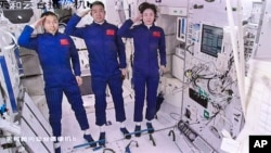 In this screengrab captured at Beijing Aerospace Control Center and released by Xinhua News Agency, Chinese astronauts from left, Liu Yang, Chen Dong and Cai Xuzhe salute after entering the space station core module Tianhe, June 5, 2022.