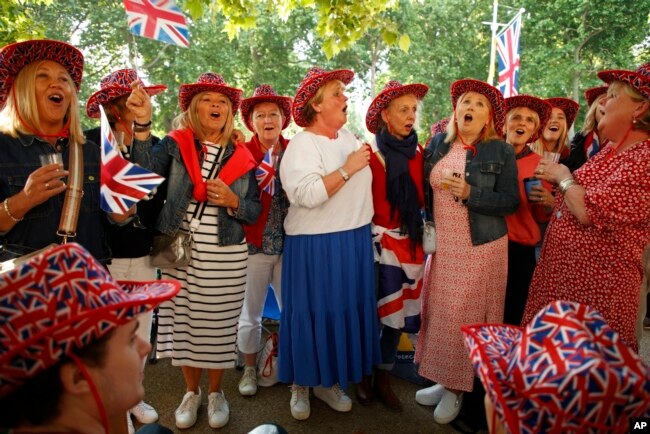 Royal fans sing the national anthem as they gather along the Mall leading to Buckingham Palace in London, Thursday June 2, 2022. (AP Photo/David Cliff)