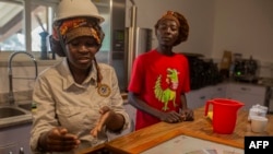 Un groupe de dégustateurs de café expliquent leur travail au centre de traitement industriel de Gorongosa Coffee à Gorongosa le 20 mai 2022.