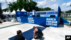 Workers set up for the "March for Our Lives" rally on the National Mall, near the White House, in Washington, June 10, 2022. The march is returning to Washington after four years.