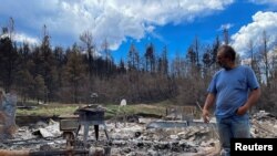 Daniel Encinias stands next to the ruins of his home destroyed by the Hermits Peak Calf Canyon fire in Tierra Monte, New Mexico, June 9, 2022. 