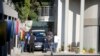 FILE - In this file photo taken on Feb. 14, 2018 a police van and uniformed and plainclothes police officers are seen inside the compound of the controversial business family Gupta in Johannesburg. 