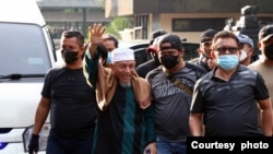 Pemimpin Khilafatul Muslimin, Abdul Qadir Hasan Baraja (tengah memakai sorban putih) didampingi para penyidik tiba di Polda Metro Jaya pada Selasa sore setelah dirinya ditangkap Selasa pagi di Teluk Betung, Bandar Lampung. (foto: courtesy) 