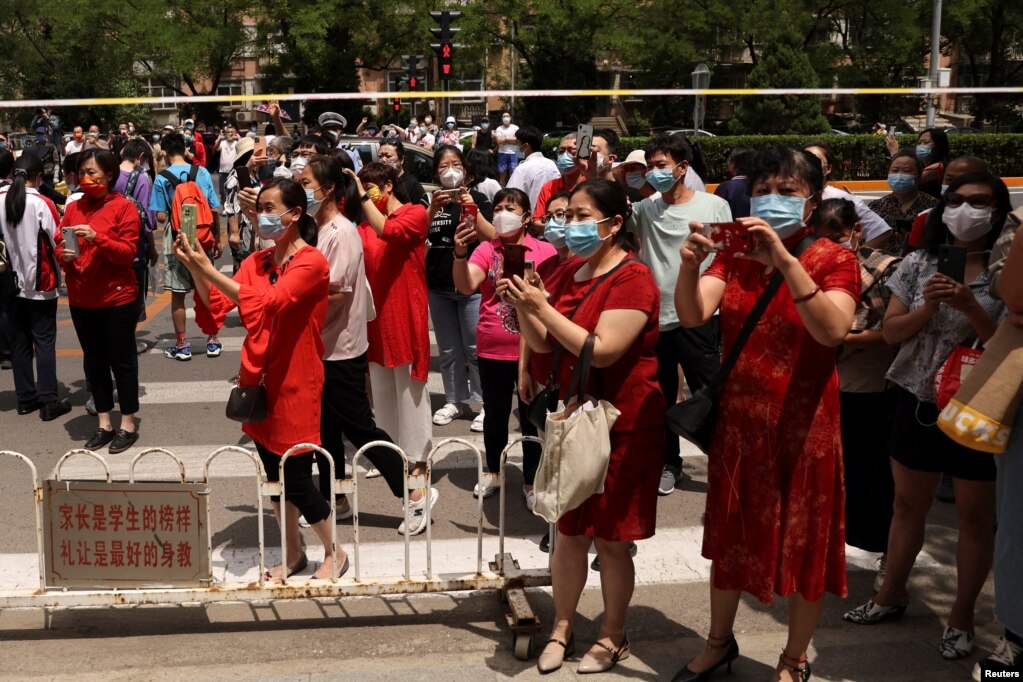 中国高考第一天，北京一处考场外在警察拉起的警戒线外等候的考生父母与亲属。（2022月6月7日）(photo:VOA)