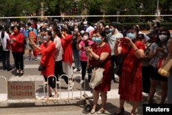 中国高考第一天，北京一处考场外在警察拉起的警戒线外等候的考生父母与亲属。（2022月6月7日）