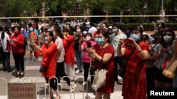 Orang tua menunggu putra-putrinya saat ujian masuk perguruan tinggi nasional tahunan, atau "gaokao", di tengah wabah COVID-19, di sebuah sekolah menengah di Beijing, China, 7 Juni 2022. (Foto: REUTERS/Tingshu Wang)