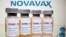 FILE PHOTO: Vials with a sticker reading, "COVID-19 / Coronavirus vaccine / Injection only" and a medical syringe are seen in front of a displayed Novavax logo on Oct. 31, 2020. 