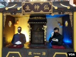 Hong Kong artist Kacey Wong (on the left) posed from his protest art installation booth in Taipei. (Joyce Huang/VOA)