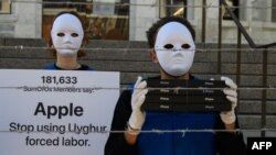 FILE - Activists set up a mock Uyghur forced labor camp outside the Apple flagship store on March 4, 2022, in Washington, DC. Demonstrators called on tech giant Apple to stop using Uyghur forced labor.