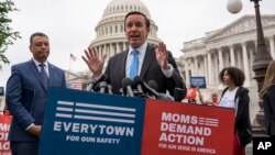 FILE - Democratic Senator Chris Murphy is joined at left by Senator Alex Padilla, also a Democrat, as they speak to activists demanding action on gun control legislation, at the Capitol, in Washington, May 26, 2022. 