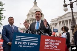 FILE - Democratic Senator Chris Murphy is joined at left by Sen. Alex Padilla, also a Democrat, as they speak to activists demanding action on gun control legislation, at the Capitol, in Washington, May 26, 2022. (AP Photo/J. Scott Applewhite)