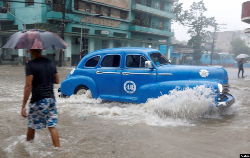 Ein der vielen Oldtimer in Kuba fährt am 3. Juni 2022 auf einer von starken Regenfällen überfluteten Straße in Havanna. | Bildquelle: VOA | Bilder sind in der Regel urheberrechtlich geschützt