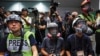 Sejumlah fotografer mengenakan alat pelindung selama konferensi media polisi di Hong Kong pada 2020. Mereka melakukan protes terhadap aksi kekerasan aparat terhadap media. (Foto: AP)