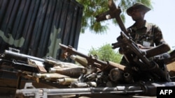 FILE - A sector commander of the Multinational Joint Task Force displays arms and ammunition recovered from Islamist insurgents during a clash with soldiers in the remote northeast town of Baga, Borno State, Nigeria, April 30, 2013. 