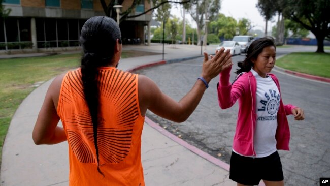 Native American students high fiving as they pass each other at the University of California, Riverside, June 26, 2014. 