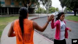 Native American students high fiving as they pass one other at the University of California, Riverside, June 26, 2014. 