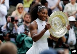 Serena Williams dari AS memegang trofi setelah memenangkan final tunggal putri melawan Angelique Kerber dari Jerman pada hari ketiga belas Kejuaraan Tenis Wimbledon di London, Sabtu, 9 Juli 2016. (Foto: AP)